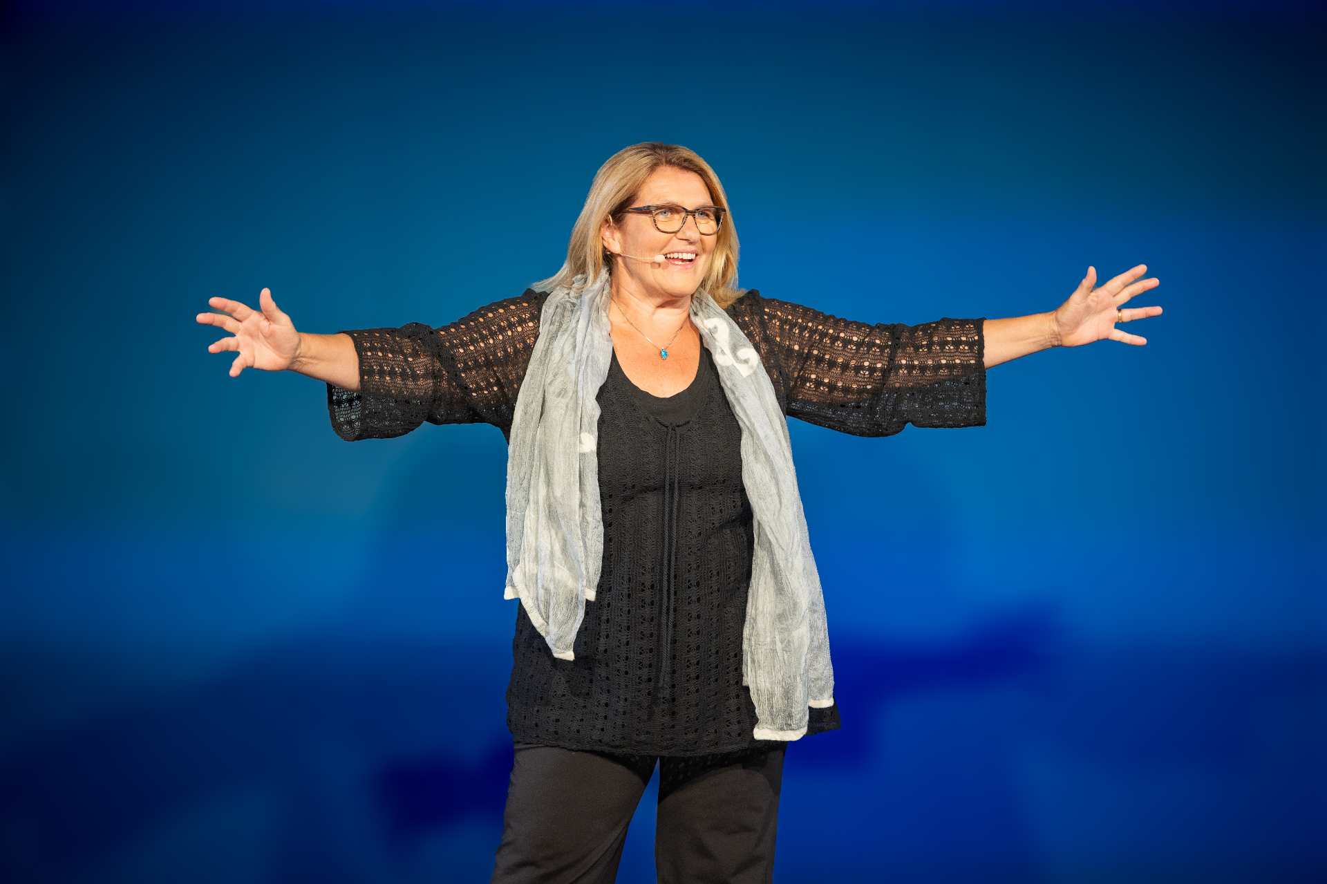 Yvonne Frei auf der Bühne mit weit ausgebreiteten Armen